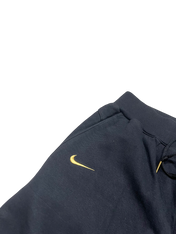 Sötétkék Nike streetwear melegítőnadrág sárga hímzett logóval, vintage stílusban