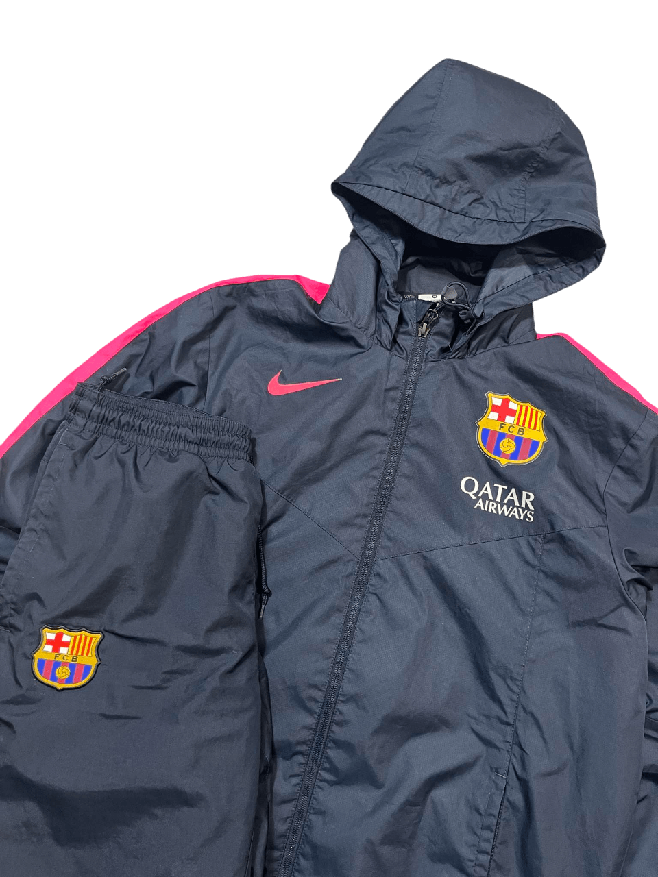 Sötétkék FC Barcelona melegítő szett kapucnis dzsekivel és nadrággal, Nike logóval.