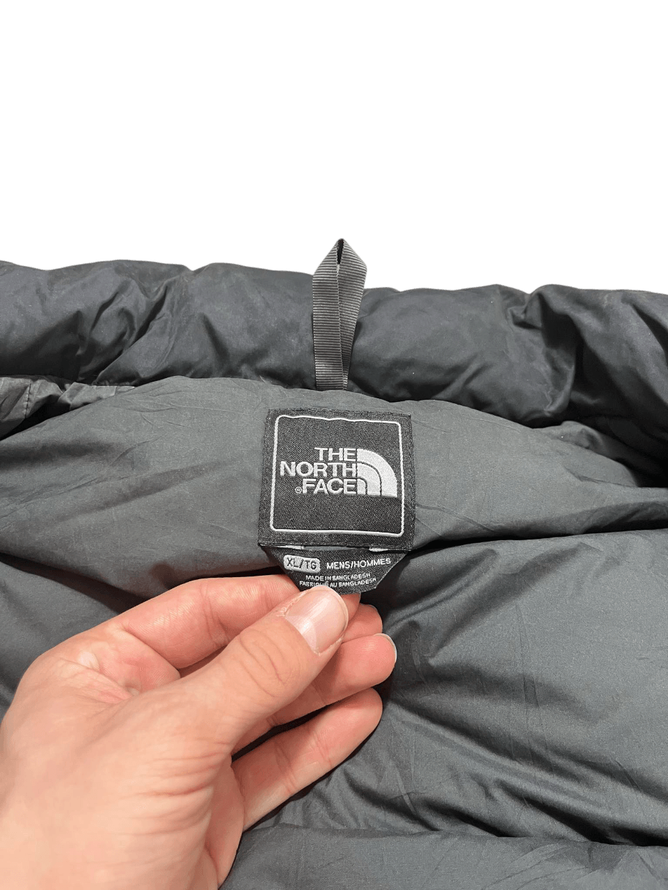 The North Face fekete pehelykabát címke közelről, vintage streetwear stílus