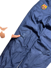 Sötétkék Barcelona logós trackpants, kis sérüléssel az anyagon, streetwear stílusban.