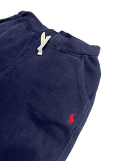 Sötétkék vintage streetwear melegítőnadrág, fehér húzózsinórral és piros hímzett logóval.